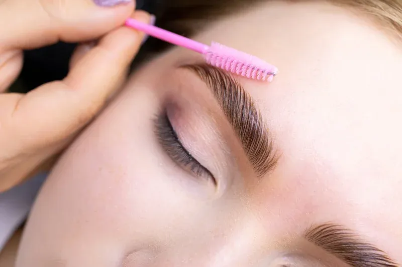 Sobrancelha sendo penteada durante o design simples, com o excesso de pelos removido